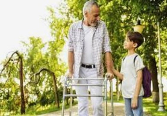 A man using a standard walker walking with his grandson.