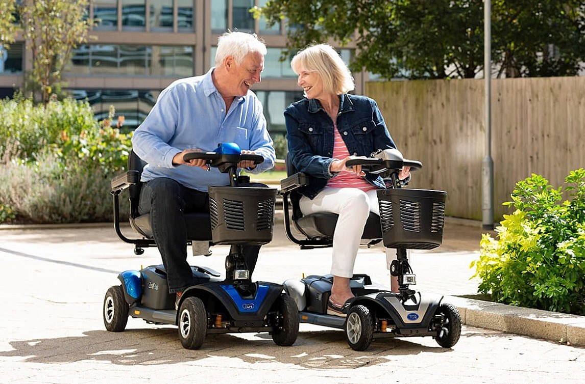 Husband and Wife Enjoying a Ride Together on 4 Wheel Travel Scooters