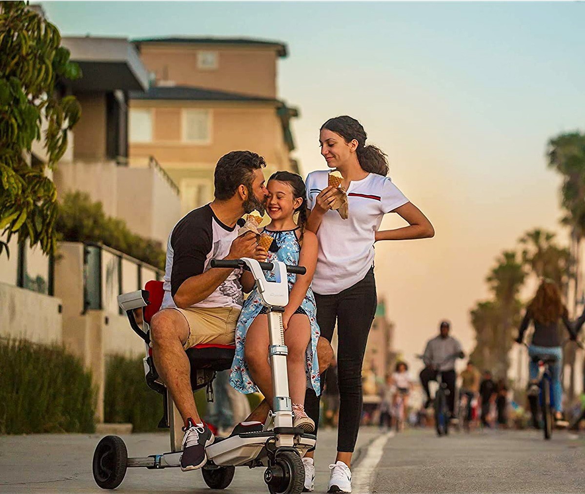 Man Riding a 3 Wheel Folding Mobility Scooter with Family