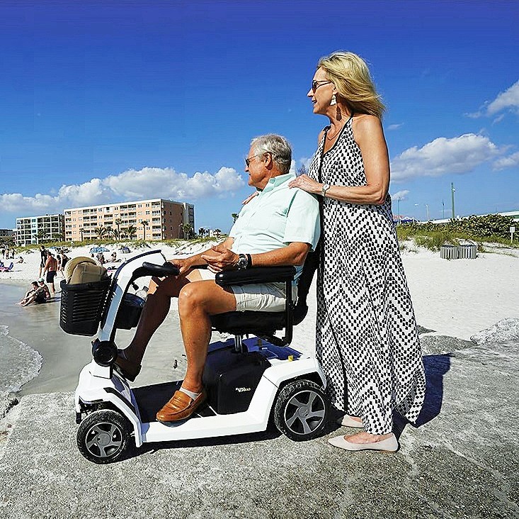 Couple Enjoying the Seashore with a 4-Wheel Recreational Scooter 