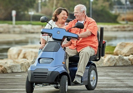 Couple enjoying a ride together on their dual seat electric scooter.