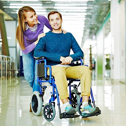 Manual Transport Wheelchair User Aided By A Caregiver