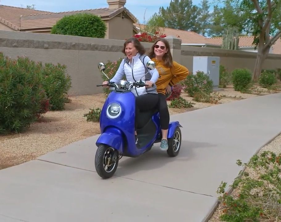 Family Members Enjoying a Ride on a 3 Wheel Two-Person Scooter